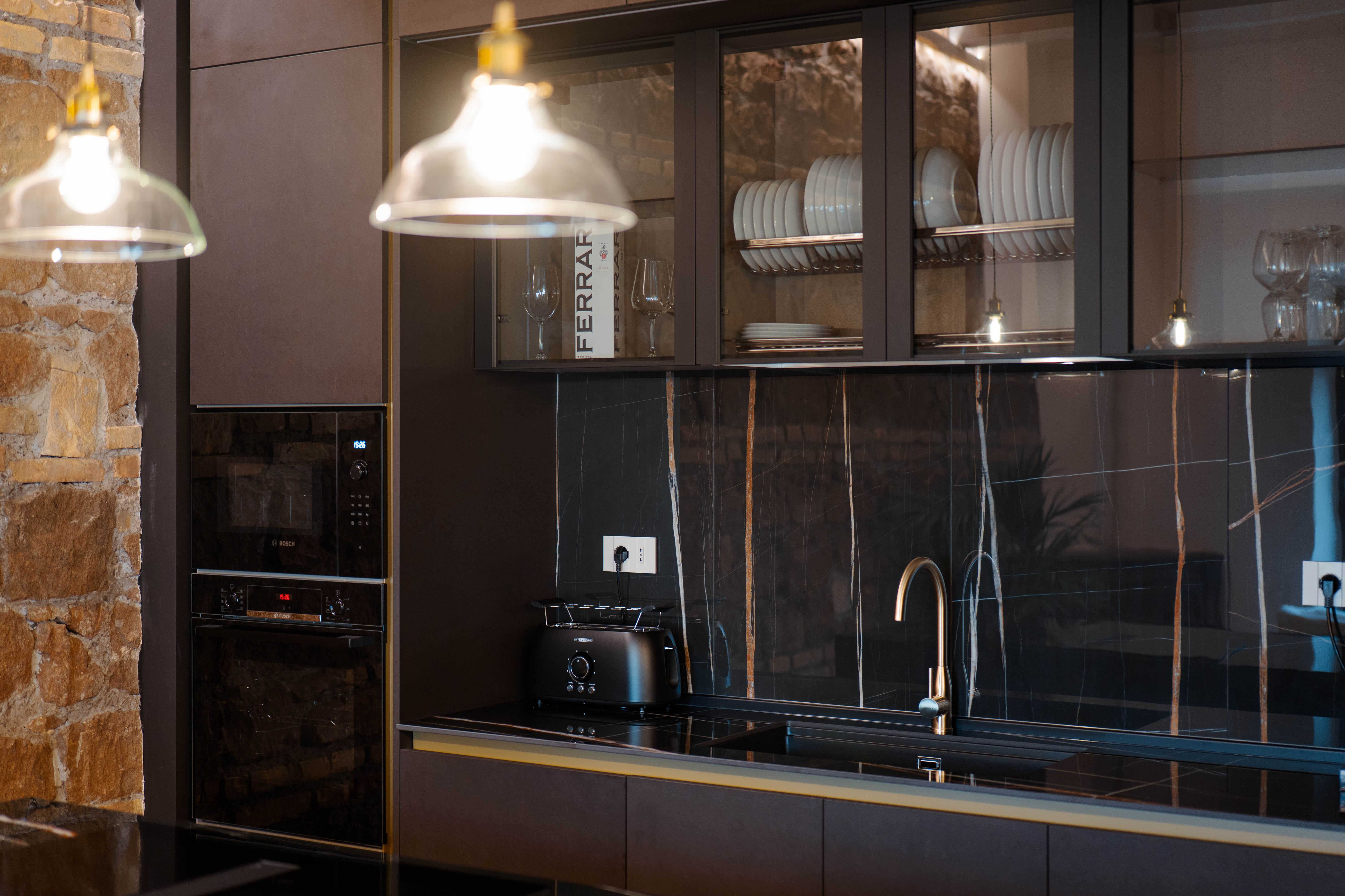 Paraschizzi in marmo scuro con piano cottura, Progetto Cucina — ristrutturazione cucina a Roma · HOME360