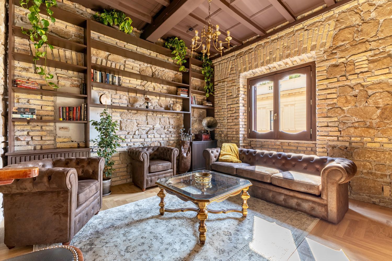 Salotto con mattoni a vista e libreria in ferro, Salotto Industrial — ristrutturazione salotto a Roma · HOME360